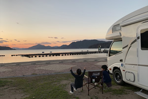 愛媛県伯方島「ドルフィンファームしまなみ」でのキャンプ風景。キャンプスペースからも時折ジャンプするイルカが見られる